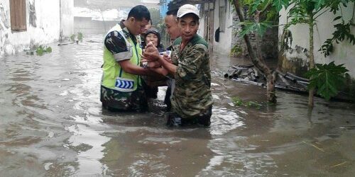 Babinsa dari jajaran Koramil Kodim Jombang bersama relawan membantu evakuasi warga yang terdampak banjir 
