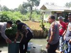 Kapolsek Pameungpeuk Kompol Rahmat Dasep bersama Kepala Desa Baros dan disaksikan oleh tokoh masyarakat memusnahkan ratusan liter miras jenis tuak ke aliran irigasi